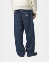 Pantalón de denim Carhartt WIP modelo Brandon Pant, color azul oscuro, de corte ancho y tiro bajo. Presenta bolsillos traseros con etiqueta cuadrada de la marca.
