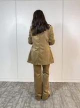 Conjunto de saco y pantalón de pana color marrón claro. El saco es de corte clásico con solapas y bolsillos delanteros. El pantalón es de corte recto y tiro alto.