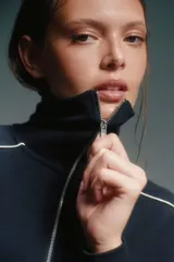 Conjunto deportivo azul marino con detalles de ribete blanco. Incluye una campera corta con cierre y un pantalón de corte recto.