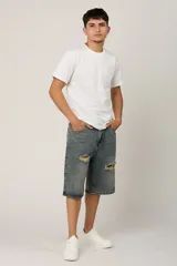 Bermuda de jean azul con efecto lavado y roturas en la parte delantera.