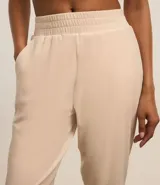 Pantalón deportivo verde oliva confeccionado en microfibra con cintura elástica.