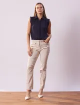 Pantalón de gabardina elastizada color beige, marca Tahari. Corte slim, pretina con pasadores, cierre y broche interno. Delantera y trasera con bolsillos.