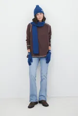 Jean de corte semi oxford con tiro medio, confeccionado en denim de lavado claro. Presenta costuras verticales decorativas en el frente y un detalle de costura en la botamanga que amplía la silueta.