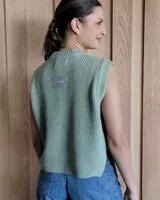 Chaleco de punto color fucsia, con cuello redondo y sisas amplias. Tiene botones de madera en los laterales.