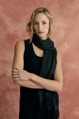 Bufanda larga color negro con pequeños apliques brillantes y flecos en los extremos.