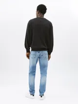 Buzo negro de corte relaxed con cuello redondo y logo Tommy Jeans tonal bordado en el pecho.