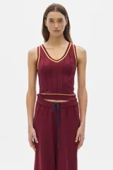 Musculosa tejida color crema con cuello en V y ribete negro.