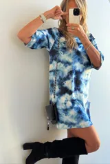 Vestido corto con estampado tie-dye en tonos azules y blancos, de corte recto y mangas cortas.