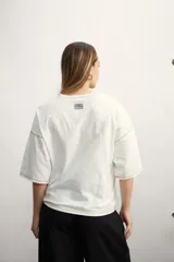 Remera color verde agua, de corte holgado y mangas cortas con dobladillo.