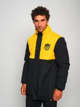 Parka de hombre bicolor negra y amarilla con escudo del club deportivo Peñarol en el pecho.