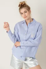 Camisa de lino color gris claro con bordado de monograma PEC en el bolsillo.