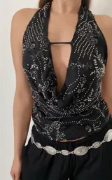 Top negro con escote halter, espalda descubierta y bordados con lentejuelas y cuentas plateadas.