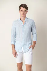 Camisa celeste a rayas verticales blancas, de lino, corte slim fit, con cuello hudson y mangas largas.