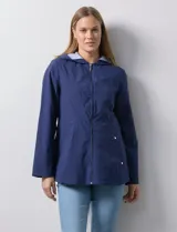 Campera impermeable azul con cierre central, bolsillos delanteros y lazo de ajuste en la cintura. Tiene avíos metálicos plateados y cierre oculto en la espalda para autoguardado.