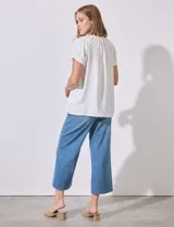 Blusa de gasa color fucsia con cuello fruncido, escote en V y lazo, ideal para combinar con jeans.