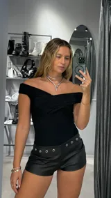 Body negro con escote off-shoulder drapeado y corte ajustado.