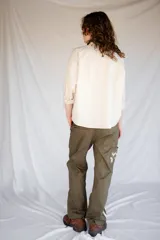 Pantalón de trabajo verde oliva, de tiro medio, confeccionado en gabardina de algodón. Presenta cinta utilitaria trasera, cintura ajustable, bolsillo para metro bordado y cinta reflectiva en los bajos.