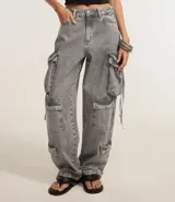 Pantalón baggy gris de jeans con bolsillos cargo laterales y tiritas ajustables.