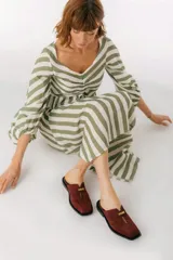 Zuecos con estampado animal print en blanco y negro, con tira ancha de cuero negro y aplique metálico.