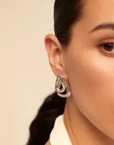 Aros de metal plateado con diseño de eslabones orgánicos superpuestos.