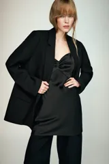 Blazer negro de manga larga con cuello solapa y cierre frontal de un solo botón. Presenta bolsillos delanteros con solapas.