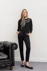 Pantalón babucha negro de calce relajado, con elástico y cordón ajustable en la cintura, bolsillos diagonales en el frente y falsos bolsillos ojal en la espalda.