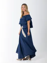 Blusa azul marino de algodón italiano, con escote elastizado que permite usarla con los hombros al descubierto o como remera con hombro abullonado. Presenta volados y mangas cortas abullonadas.