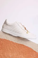 Zapatillas bajas de gamuza celeste con cordones y pañuelos estampados atados a los cordones.