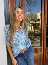 Blusa celeste con estampado floral en tonos azules, cuello mao con escote en V y cartera con botones de nácar.