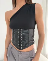 Corset negro de cuero sintético con cierre de cordones frontales y top asimétrico de un hombro.