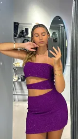 Minivestido violeta con brillos, strapless y corte ajustado.