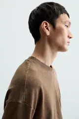 Camiseta azul marino de corte holgado, confeccionada en algodón con cuello redondo y mangas cortas. Presenta un efecto de lavado que le da una apariencia única.