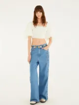 Pantalón de jean celeste, de corte wide leg y tiro medio, con cordones entrelazados a lo largo de los laterales.