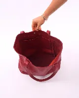 Bolso tote de cuero color bordó, con broche de cierre, bolsillo interior y porta llaves.