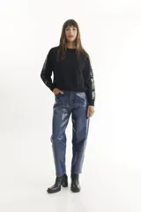 Pantalón de jean azul con estampado de cuadrados plateados.