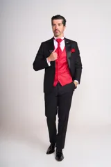 Traje de ceremonia negro con chaleco, corbatín y pañuelo de bolsillo rojos.