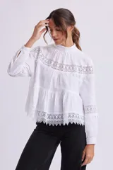 Blusa blanca de manga larga con cuello alto y detalles de encaje.