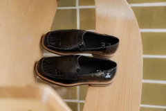 Mocasines de cuero marrón con diseño de cocodrilo, suela plana y detalle de antifaz en el empeine.