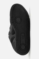 Zapatilla deportiva tipo skate color negro. Parte superior fabricada en combinación de piezas y materiales. Detalle de cordones maxi y suela con acabado irregular.