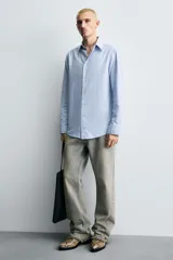 Botín de cuero con estampado de serpiente, corte a la altura del tobillo, punta fina, cierre lateral con cremallera y tacón bajo.