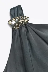 Vestido midi de satén color gris oscuro, con escote asimétrico, manga sisa, detalle de aplique dorado en el hombro y frunces laterales.