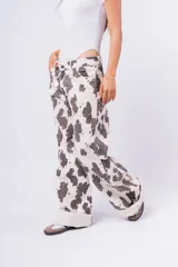 Pantalón wide leg color crudo con estampado de manchas de vaca en color gris oscuro.