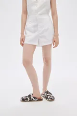 Short blanco de lino, de tiro alto y corte holgado.