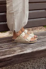 Sandalia de cuero con dos hebillas y textura de croco en color dorado.