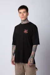 Remera blanca de algodón de corte oversize con mangas cortas y cuello redondo. Presenta un pequeño estampado en el frente con la figura de Mickey Mouse y caracteres orientales.