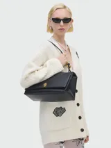 Bolso de hombro grande Marc Jacobs The Large Dual, color negro, con solapa frontal y herrajes dorados.