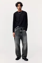Pantalón de jean gris oscuro con efecto lavado, corte holgado, tiro bajo y cinco bolsillos.