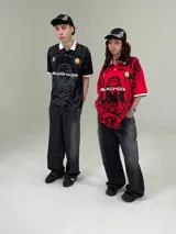 Camisa deportiva unisex con cuello polo, mangas cortas con ribete blanco y estampado con diseño abstracto en negro y gris.