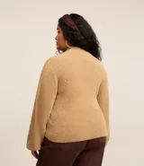 Suéter color beige de punto con textura de pelitos, cuello alto y mangas largas.