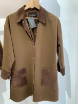 Camisa marrón de tejido de punto en lana con cuello y bolsillos de cuero, con cierre frontal de botones a presión.